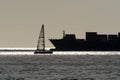 Sail boat and big container ship silhouette Royalty Free Stock Photo