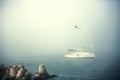 Sail boat in the foggy sea in a calm early morning Royalty Free Stock Photo