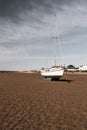 Sail boat moored with an anchor on the beach at low tide at Instow beach North Devon Royalty Free Stock Photo