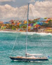 A sailboat sails in front of a Colorful hillside in Puerto Rico beach front