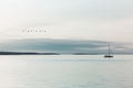 Sail boat sails quietly in the ocean illuminated by a surreal light