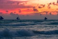 A sail boat yacht on the horizon at sunset silhouette against the setting sun orange sky behind clouds Royalty Free Stock Photo