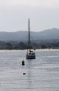 Sailboat Anchored In Bay With Hills In Background Royalty Free Stock Photo