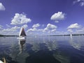 Sailboat on beautiful lake on blue sky and pleasant green landscape background and lovely reflection on water surface. Royalty Free Stock Photo
