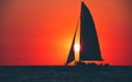 Sailboat. Beautiful seascape with silhouette of sail boat or luxury yacht on horizon. Ocean sunset and red sky. Summer vacation. Royalty Free Stock Photo