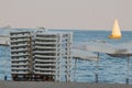 Sailboat Behind Sunbeds on Varna Beach Royalty Free Stock Photo