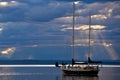 A sailboat on a calm sea at dusk