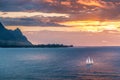 Sailboat crosses sunset on Kauai island coast Royalty Free Stock Photo