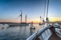 Sailboat Dingy Sails Between Wooden Boats at Sunset Royalty Free Stock Photo