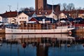 Sailboat docked in a calm and tranquil marina, with a number of residential houses in the background Royalty Free Stock Photo
