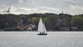 Sailboat in front of historic and modern windmills Royalty Free Stock Photo