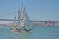 Sailboat in front of Ponte 25 de Abril bridge over Tagus river Royalty Free Stock Photo