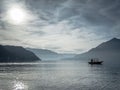 Sailboat gliding across a tranquil lake surrounded by lush greenery