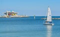 A sailboat heading toward the St Petersburg Pier. It is going to Tampa Bay in Florida.