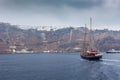 Sailboat heading towards the port of Fira village, Santorini Island Royalty Free Stock Photo