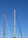 Sailboat masts in the marina against a blue summer sky