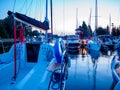 Sailboat moored on wooden jetty in the port at the evening time, view on sailing yacht deck with rigging Royalty Free Stock Photo