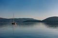 Sailboat in the morning against the mountains.