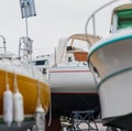 Sailboat between motorboats in boatyard view.. Royalty Free Stock Photo