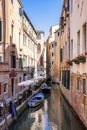 Sailboat on narrow canal between residential buildings