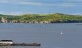 Sailboat navigates near Twillingate cliffs, seascape, landscape, Newfoundland, Atlantic Canada. Royalty Free Stock Photo
