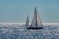 Sailboat on ocean backlit with sun shinning