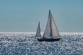 Sailboat on the ocean with sun light reflections and blue sky Royalty Free Stock Photo