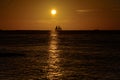 Sailboat on the ocean at sunset. Yacht against sunrise background. Beautiful sunset over ocean with boat sailing. Royalty Free Stock Photo