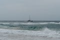 Sailboat off the coast of Kauai`s remote beach at the edge of the Napali Coast Royalty Free Stock Photo