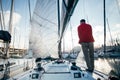 Man washes folded sail on boat or yacht in port