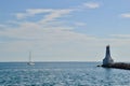Sailboat passing by Cobourg East Pierhead Lighthouse