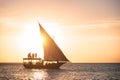 Sailboat with people in ocean at sunset in summer Royalty Free Stock Photo