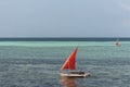 Sailboat with red sail on the sea. Reggata concept. Marine race. Yacht with red sail on tropical seascape. Summer recreation.