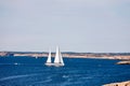 Sailboat and rocky coast Royalty Free Stock Photo