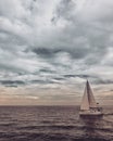 Sailboat sailing towards the horizon at sunset Royalty Free Stock Photo