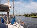 Sailboat with sails down motoring in Lemmer canal, Friesland, Netherlands