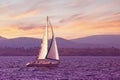 Sailboat sails near shore of Bay of Kotor at sunset. Montenegro. Travel concept Royalty Free Stock Photo