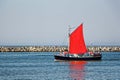 Sailboat with scarlet sails and sailors on board