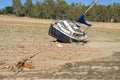 sailboat stranded on land due to drought with blue sky trees in the background horizontal Royalty Free Stock Photo