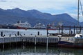 Sailboat at a wooden pier in Ushuaia Harbor with the commercial pier in the background