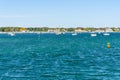 Sailing boats anchored in blue waters off a wooded coast in autumn Royalty Free Stock Photo