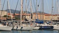 Sailboats anchored to the dock of the port. In the background th