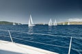 Sailboats compete in a sail regatta at sunset, race of sailboats, reflection of sails on water, multicolored spinnakers