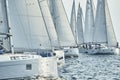 Sailboats compete in a sailing regatta at sunset, sailing race, reflection of sails on water, white color of sails, boat