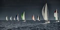 Sailboats compete in a sailing regatta at sunset, sailing race, reflection of sails on water, multi-colored spinaker