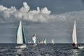 Sailboats compete in a sailing regatta at sunset, sailing race, reflection of sails on water, multi-colored spinaker