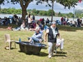 Sailboats fans enjoy big outdoor entertainment event. Open air festival Picnic. Big group of people on grass waiting for armada