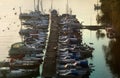 Sailboats and motorboats moored to a jetty