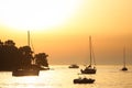 Sailboats near coast at sunset Royalty Free Stock Photo