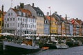 Sailboats next to colorful buildings in the port of Nyhaven in Copenhagen, Denmark.